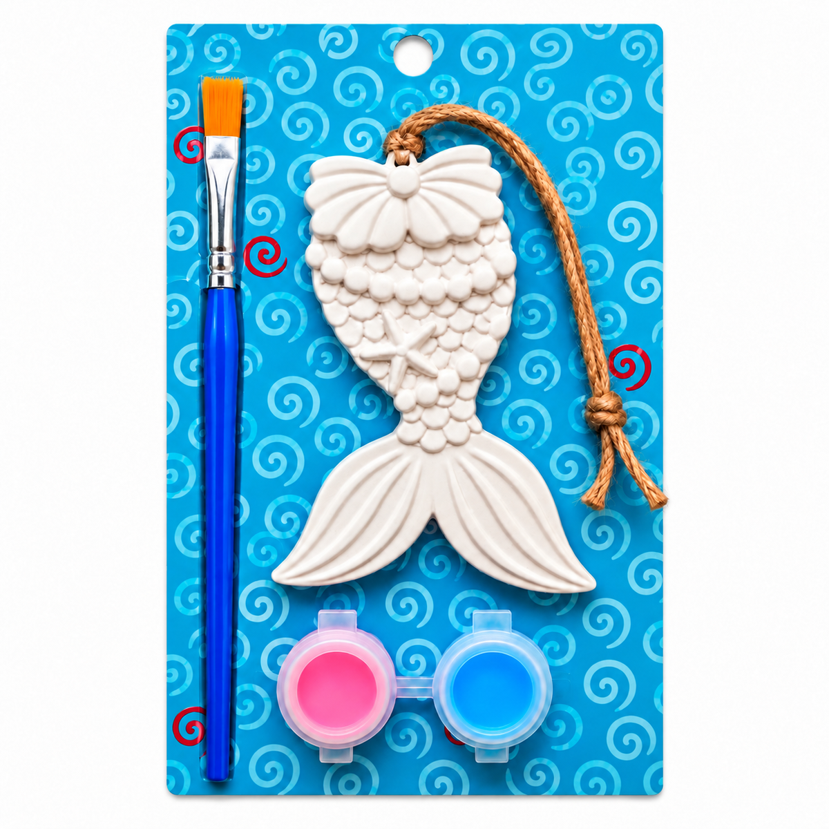 Mermaid tail plaster paint kit on a blue patterned backing card, including a white plaster mermaid tail ornament with a jute hanging string, a blue-handled paintbrush with an orange bristle, and two small paint pots with pink and blue paint.