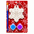 A festive holiday plaster craft kit on a red backing card, featuring a white snowflake ornament, a blue-handled paintbrush, and two small paint pots with blue and purple paint.