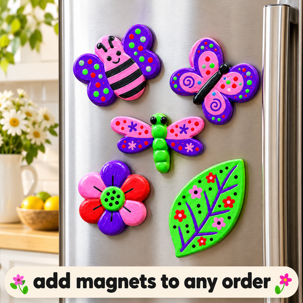 Five colorful decorative refrigerator magnets shaped like a butterfly, flower, leaf, dragonfly, and another butterfly, arranged on a stainless steel fridge. A blurred kitchen scene with flowers and fruit appears in the background, and a text banner at the bottom says 'add magnets to any order'.